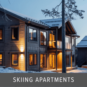Glass balustrade installed on the balcony of a timber-clad ski apartment building, photographed at dusk with snow on the ground and lit windows.