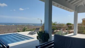 Contemporary stainless steel wire balustrade installed on a poolside terrace, offering panoramic coastal and ocean views.