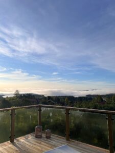 Morning view from timber deck with corner glass balustrade, overlooking misty landscape and adding stylish outdoor safety.