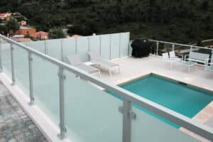Stylish frosted safety glass fence installed on a timber deck around pool, providing effective privacy screening and modern appeal.