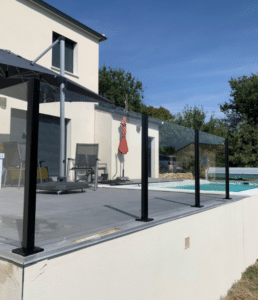 Secure laminated glass pool fencing with black aluminium posts enclosing an elevated terrace with a sleek and modern outdoor setup.