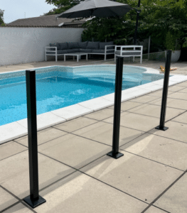 Modern glass railing with black posts mounted on white tiles around villa pool – stylish, low-maintenance, and CE-certified safe.