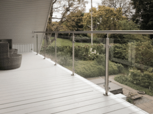 Balcony with stainless steel glass balustrade and handrail, overlooking lush garden – ideal for modern home terraces.